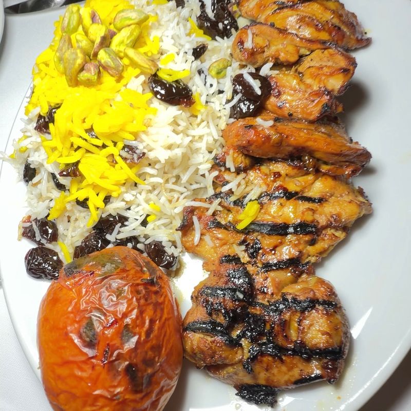 Saffron rice with grilled chicken and a grilled tomato