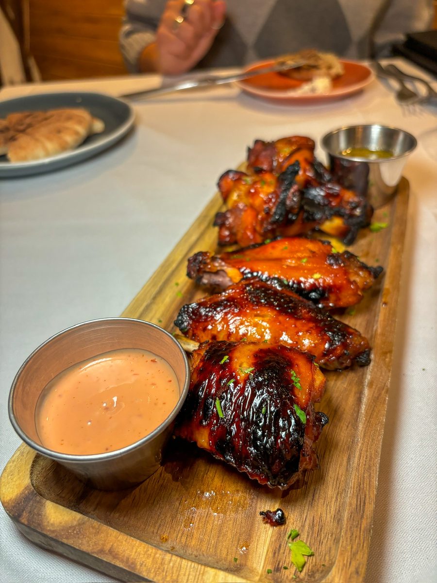 Shiraz Wings on a wooden board with two dipping sauces